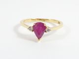un gros plan d'une bague en or jaune sertie d'un rubis en forme de poire