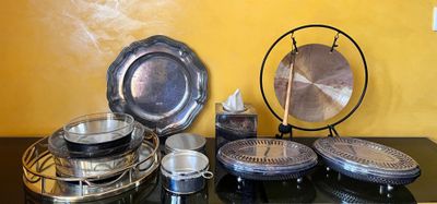 une table sur laquelle sont disposés de nombreux plats et casseroles en argent
