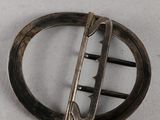 a silver brooch with a curved design on it