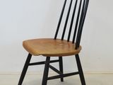 a black chair with a wooden seat on a white floor