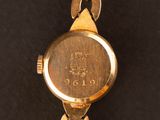 an image of a close up of a gold watch on a black surface