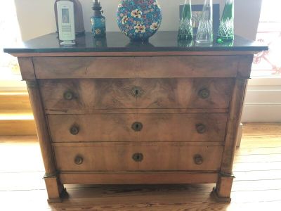 a dresser with bottles and a vase on top of it