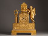 a gold clock with an angel on top of it