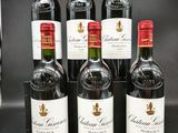 six bouteilles de vin rouge sont alignées sur une table