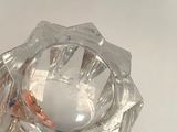 a glass candle holder with a candle inside of it