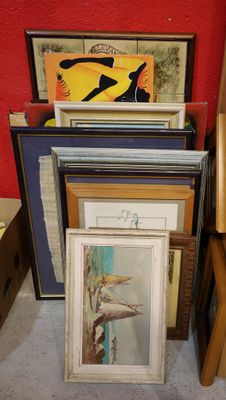 a lot of framed art on the floor next to a chair