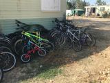 many bikes lined up against the side of a house