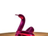 a purple sculpture of a snake on a wooden table