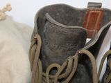 a pair of boots that are next to a bag