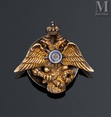 a gold brooch with an eagle and a crown on it