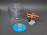 a small toy airplane sitting next to a plastic container