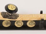 a black and gold object on a stand with coins