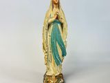 a statue of a woman holding a rosary in her hands