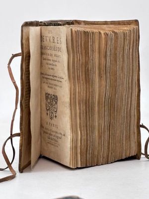 un vieux livre ouvert sur une surface blanche