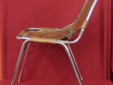 a metal chair with a wooden seat on a red background