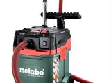 un aspirateur vert et rouge muni d'un tuyau rouge