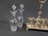 two glass vases and a silver plate stand on a table