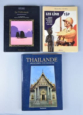 trois livres posés sur une table, avec une statue d'un homme devant un bâtiment