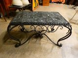 une table noire avec un plateau en marbre dans une pièce