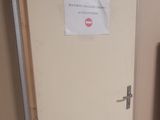 a toilet in the corner of a room with a sign on the door