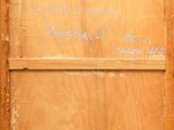 a wooden door with writing on it in a room