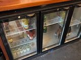 un petit réfrigérateur sur lequel sont posées de nombreuses bouteilles