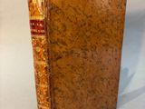 an old book sitting on top of a white surface