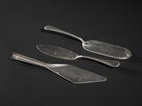 three pieces of silverware sitting on top of a black surface
