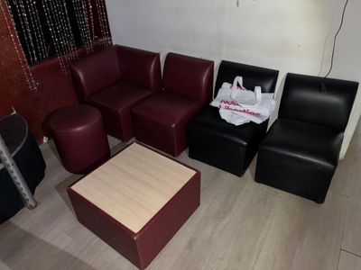 plusieurs chaises et une table dans une pièce avec un rideau rouge