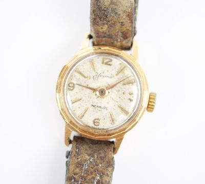 une image d'un gros plan d'une montre-bracelet sur une surface blanche