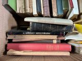 many books stacked on top of each other in a box