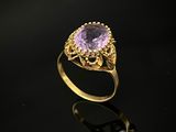 une bague en or sertie d'une pierre ovale d'améthorate entourée de filigranes
