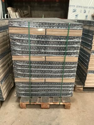 a pile of metal sheets stacked on top of pallets in a warehouse