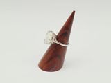 a close up of a wooden cone with a ring on it