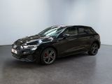 a black car parked in a room with a white wall