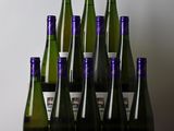 Des bouteilles de vin sont alignées sur une table devant un mur blanc
