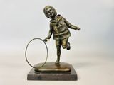 bronze statue of a girl with a hoop on a marble base