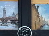 deux tableaux accrochés au mur d'un immeuble sur lequel se trouve une horloge