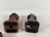 three figurines of a man and a woman sitting on a bench