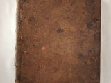 an old book sitting on top of a white table next to a window