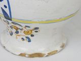 a white vase with a blue and yellow design on it
