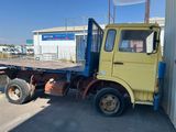 un camion jaune garé devant un immeuble