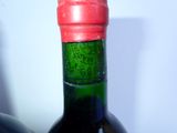 a bottle of wine that has a red cap on it