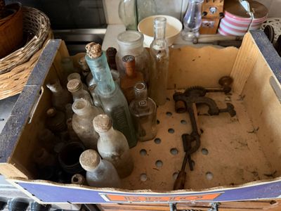 une boîte remplie de vieilles bouteilles et des bouteilles posées sur le comptoir