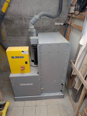 une machine qui se trouve dans une pièce, à côté d'un tas de bois