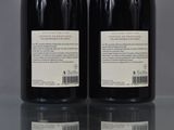 two bottles of wine sitting on top of a table next to each other