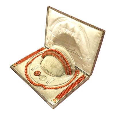 un écrin en argent contenant un collier de perles rouges