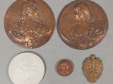 two coins and a coin with a picture of a woman on them