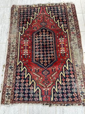 a red and black rug on a tile floor