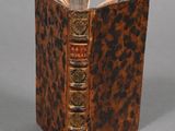an old book with a brown cover sitting on top of a table